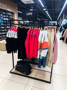 Kyiv, Ukrayna - 18 Aralık 2024: Canlı spor giysileri ve modern bir iç mekanın ortasındaki bir mağazada sergilenen bir vitrin rafı.