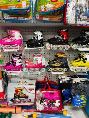 Kyiv, Ukraine - December 18, 2024: A selection of vibrant roller skates with accessories organized on a store shelf. clipart