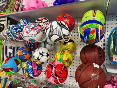 Kyiv, Ukrayna - 18 Aralık 2024: Renkli ve çeşitli spor toplarının sergilendiği bir mağaza rafının görüntüsü. Basketbol topları, futbol topları ve voleybol topları gibi çeşitli tipler düzenli olarak düzenlenir, birden fazla spor aktivitesi için mükemmeldir.