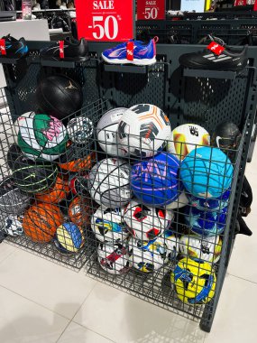 Kyiv, Ukrayna - 18 Aralık 2024: Çeşitli spor topları ve ayakkabılar% 50 indirimle satışa sunuldu. Eşyalar arasında basketbol topları, futbol topları ve spor ayakkabıları, sepetlerde düzenli olarak düzenlenenler ve perakende mağazalarında görülen belirgin satış tabelaları yer alıyor..