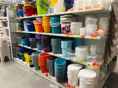 Kyiv, Ukrayna - 03 Ocak 2025: Bir mağazada çeşitli renk ve boyutlarda plastik kova ve kaplar sergilenen organize raflar. Bu ev ürünleri müşteriler için düzenli olarak düzenlenmiştir, temiz bir perakende ortamı göstermektedir.