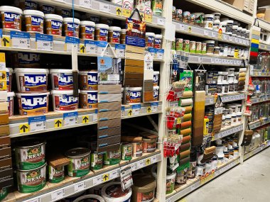 Kyiv, Ukrayna - 03 Ocak 2025: Konserve kutuları ve ev geliştirme projelerinde kullanılan araçlar da dahil olmak üzere çeşitli boya malzemelerini gösteren rafları göster.