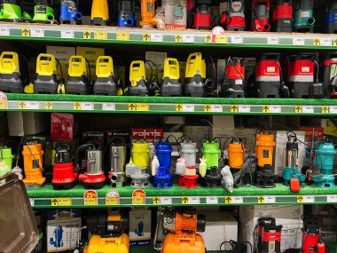 Kyiv, Ukraine - January 03, 2025: A selection of colorful submersible water pumps arranged on shelves in a hardware store. The display showcases various brands, models, and sizes suitable for home and professional applications. clipart