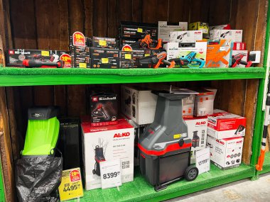 Kyiv, Ukraine - January 03, 2025: Wide variety of tools and garden equipment showcased on vibrant green shelves in a store, offering options for home improvement and landscaping projects.  clipart