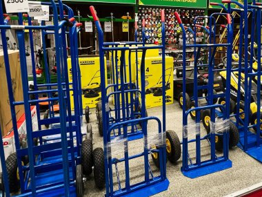 Kyiv, Ukrayna - 03 Ocak 2025: Tramvaylar olarak da bilinen mavi el kamyonları bir nalbur dükkanının koridorunda sergilenmektedir. Bu ekipmanlar ağır eşyaları taşımak için kullanılır..