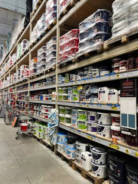 Kyiv, Ukrayna - 03 Ocak 2025: Çeşitli boya kovaları, canlı renkler ve ilgili malzemelerle dolu uzun rafların yer aldığı bir hırdavatçı dükkânı. Ev geliştirme ve DIY projeleri için mükemmel.