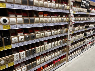 Kyiv, Ukrayna - 03 Ocak 2025: Bir hırdavatçıdaki raflarda çok çeşitli elektrik prizleri ve düğmeleri düzgünce sergilenmektedir, kurulum ve kullanım için çeşitli tasarım ve modeller sergilenmektedir. 