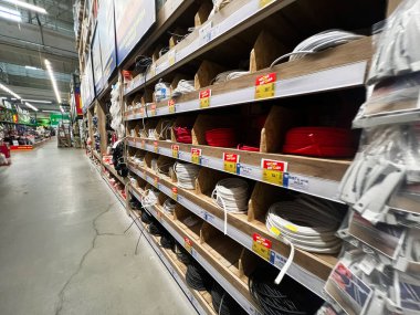 Kyiv, Ukrayna - 03 Ocak 2025: Bir nalbur dükkanında elektrik kabloları ve kablolarla dolu rafların ayrıntılı bir görüntüsü. Donanım parçaları ve aksesuarların organize çeşitleri sergilenmekte olup, ticari perakende ayarlarının net bir temsili sunulmaktadır. 