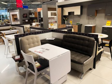 Kyiv, Ukraine - January 03, 2025: A showroom display featuring modern kitchen furniture, including dining tables, chairs, and sofas, creatively designed and organized to showcase comfort and practicality in a contemporary living space. clipart