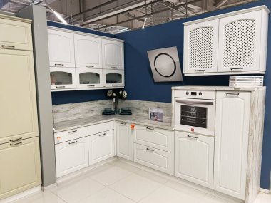 Kyiv, Ukrayna - 03 Ocak 2025: Beyaz dolaplar, modern dahili fırın ve minimalist dekorun yer aldığı şık bir mutfak. Tasarım, temiz çizgiler, geniş depolama çözümleri ve işlevsellik ve estetiğin uyumlu bir karışımını içerir..