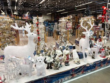 Kyiv, Ukrayna - 3 Ocak 2025: Yapay ren geyikleri, kutup ayıları, süsler ve diğer Noel temalı ürünler de dahil olmak üzere bir mağazada bir dizi bayram süslemesi sergilenmesi, neşeli ve sezonsal bir atmosfer yaratıyor.. 