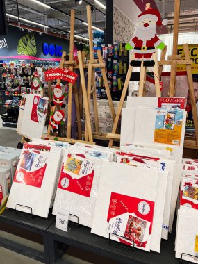Kyiv, Ukrayna - 3 Ocak 2025: Boya setleri ve mevsimlik Noel Baba dekorasyonlarının yer aldığı bir sanat malzemeleri bölümü, tüketiciler için yaratıcılık ve festival atmosferini vurguladı.