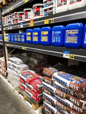 Kyiv, Ukrayna - 03 Ocak 2025: Hırdavatçı raflarında mavi plastik kaplar ve çantalar da dahil olmak üzere çeşitli inşaat malzemeleri sergilendi.