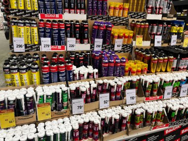 Kyiv, Ukrayna - 03 Ocak 2025: Bir hırdavatçıda birden fazla marka ve ürün tiplerinin sergilendiği çeşitli yapısal yapıştırıcılar ve çökeltilerin sergilenmesi. Düzenleme, inşaat içinde fiyat, ambalaj ve ürün çeşitliliğini vurgular