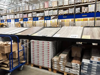 Kyiv, Ukrayna - 03 Ocak 2025: Depo tarzı bir ev geliştirme mağazasında döşeme sergisi, çeşitli ahşap dokular, renkler ve desenler sergilenmektedir. Döşeme kutuları düzgünce satılık..