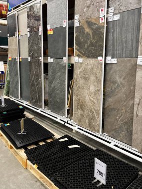 Kyiv, Ukrayna - 03 Ocak 2025: Görüntü, bir perakende mağazasında müşteri seçimi için standlarda sergilenen taş kiremitleri gösteriyor. Farklı iç tasarım seçeneklerini yansıtan farklı renkler ve dokular görünür..