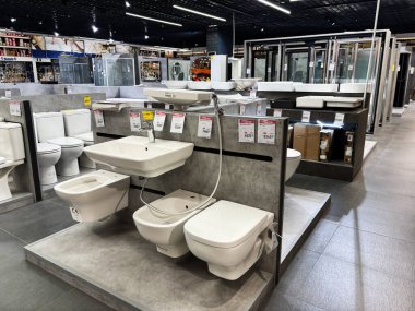 Tuvaletler, lavabolar ve gösterişli tuvaletler de dahil olmak üzere çeşitli modern banyo armatürlerinin sergilendiği bir sergi salonu..