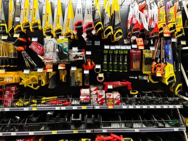 Kyiv, Ukrayna - 03 Ocak 2025: Testereler, tornavidalar ve bir hırdavatçıda düzgün bir şekilde düzenlenmiş ekipmanlar dahil olmak üzere geniş bir ahşap işleme araçları çeşidi. DIY projeleri ve profesyonel marangozluk işleri için mükemmel.