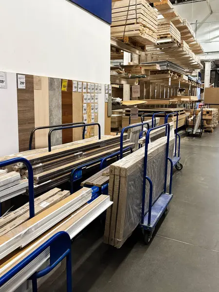 Kyiv, Ukrayna - 03 Ocak 2025: Bir hırdavat dükkanındaki el arabaları ve raflarda organize edilen ahşap döşemeler, paneller ve ekipmanlar sistematik olarak kolay erişim için istiflenmiştir..