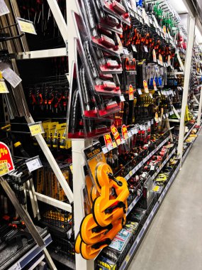 Kyiv, Ukrayna - 03 Ocak 2025: Bir mağaza koridorunda raflarda sergilenen geniş bir alet ve donanım koleksiyonu. Tornavidalar, kıskaçlar ve el aletleri de dahil. İnşaat, bakım ve DIY kavramlarını göstermek için mükemmel..