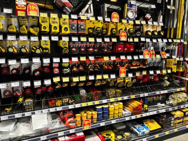 Kyiv, Ukraine - January 03, 2025: Various brands and designs of measuring tapes and tools are neatly organized on store shelves for customers. This image captures the abundance and variety available in hardware accessories. clipart