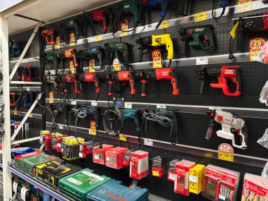 Kyiv, Ukraine - January 03, 2025: A diverse assortment of power tools, including drills and accessories, arranged neatly for display on store shelves, illustrating hardware options for professional and DIY projects. clipart