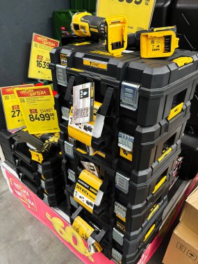 Kyiv, Ukraine - January 03, 2025: Organized stack of black toolboxes containing power tools, showcased in a hardware retail store setting. Price tags and promotional discounts are visible, indicating a sales event highlighting discounted tools and st clipart