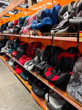 Kyiv, Ukraine - January 03, 2025: Colorful child safety car seats are neatly arranged on shelves in a store for display. The selection includes various styles and colors, offering choices suitable for different preferences and needs.  clipart