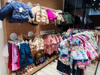 Kyiv, Ukrayna - 4 Ocak 2025: Modern bir mağazada canlı bir çocuk kışlık ceketi ve kar pantolonu sergileniyor. Çeşitli tasarımlar, renkler ve boyutlar stil ve işlevsellik ihtiyaçlarına hizmet eder. 