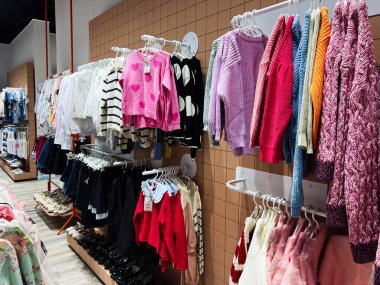 Kyiv, Ukrayna - 4 Ocak 2025: Renkli kazak, gömlek ve ayakkabıların raflarda sergilendiği mağaza. 