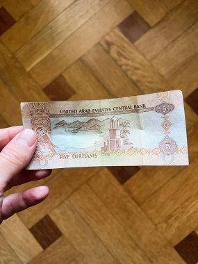 Kyiv, Ukrayna - 07 Ocak 2025: BAE 'nin geleneksel para birimi tasarımı ve ayrıntılarını gösteren, elle tutulan beş dirhem banknotu.