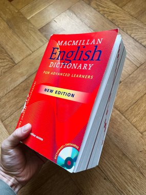 Kyiv, Ukrayna - 07 Ocak 2025: Ahşap zemine karşı kırmızı kapaklı İleri Öğrenciler için MacMillan İngilizce Sözlüğü. Özellikler bir CD, güncellenmiş sürüm ve dil geliştirme ve akademik referans için bir kaynaktır.