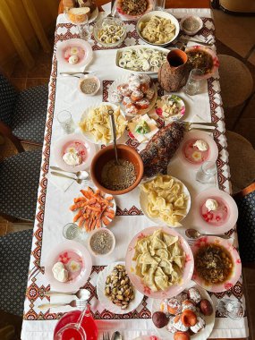 Geleneksel bir ziyafetin tepeden tırnağa görüntüsü çeşitli yemekler, hamur işleri ve içeceklerle süslenmiş güzel bir masa, kültürel ve aşçılık gelenekleri sergileniyor..