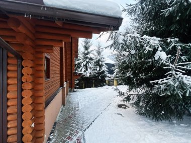 Karla kaplı ağaçlar ve kış manzarasıyla çevrili, huzurlu ve rahat bir atmosferle çevrili güzel bir ahşap kulübe. Mevsimlik temaları temsil etmek için idealdir, doğa geri çekilir, ya da soğuk iklimlerde seyahat yerleri.