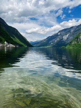 Bereketli yeşillik ve dramatik tepelerle çevrili sakin ve berrak bir göl manzarası huzurlu ve huzurlu bir doğal manzarayı yansıtıyor. Hallstatt, Avusturya.