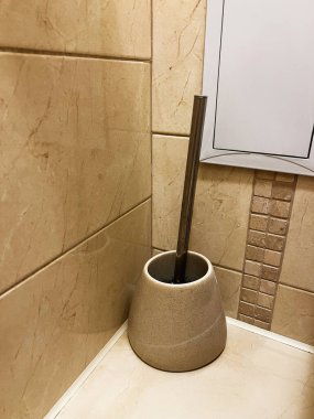 Kullanıcısının içinde sergilenen tuvaletler için bir temizlik fırçası, modern ve işlevsel tasarımla döşenmiş bir banyoya yerleştirilmiş, iç dekorasyonlar veya hijyenle ilgili kavramlar için uygun..