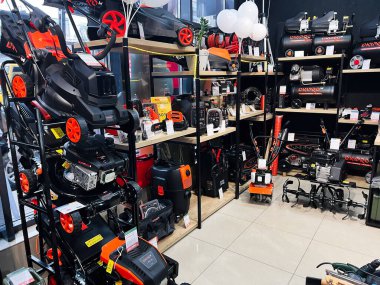 Kyiv, Ukrayna - 4 Şubat 2025: Raflarda çeşitli elektrikli aletler, biçme makineleri ve bakım ekipmanları bulunan bir mağaza