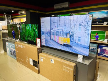 Kyiv, Ukrayna - Şubat 04, 2025: Geniş ekran televizyonlar ve sergilenen ambalajlı ambalajlar içeren elektronik mağaza