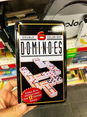 Kyiv, Ukrayna - Şubat 04, 2025: Domino, seyahat dostu bir teneke kutuya paketlenmiş, çoklu oyun talimatları ile ayarlandı.