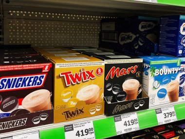 Kyiv, Ukraine - February 04, 2025: Boxes of branded hot chocolate drink pods organized on a shelf in a store. clipart