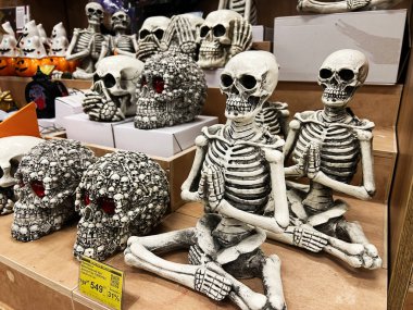 Kyiv, Ukraine - February 04, 2025: Various decorative skeletons and skulls showcased on shelves for Halloween celebration. clipart