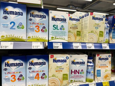 Kyiv, Ukraine - February 04, 2025: Product packaging of baby foods and cereals on a supermarket shelf under light. clipart