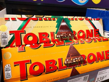 Kyiv, Ukraine - February 04, 2025: Close-up of vibrant triangle Toblerone bars placed on store shelves, showcasing flavors. clipart