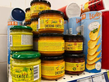 Kyiv, Ukrayna - Şubat 04, 2025: Bir süpermarkette sergilenen peynir ve guacamole de dahil olmak üzere çeşitli soslar.