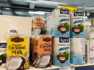 Kyiv, Ukraine - February 04, 2025: An organized display of various coconut milk brands at a grocery store. clipart