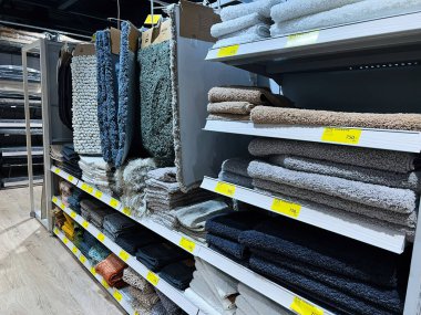 Kyiv, Ukrayna - Şubat 04, 2025: Bir perakende mağazasında çeşitli halı ve tekstil sergilenen raflar.