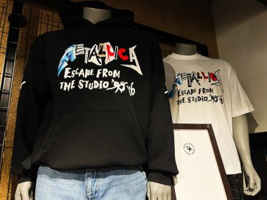 Kyiv, Ukraine - February 05, 2025: Rock Metallica band hoodies and t-shirts on display, highlighting escape-themed apparel and branding. Escape from studio. clipart