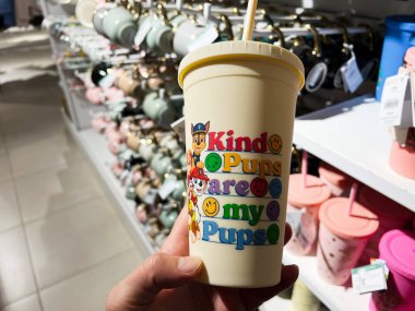 Kyiv, Ukraine - February 05, 2025: Close-up of a hand holding a plastic tumbler with Paw Patrol colorful design in a shop clipart