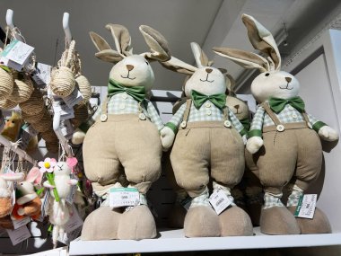 Kyiv, Ukraine - February 05, 2025: Adorable cloth rabbit figures arranged on shelves, featuring festive spring-themed designs clipart