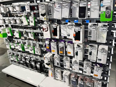 Kyiv, Ukrayna - 05 Şubat 2025: Çeşitli cep telefonu aksesuarları ve koruyucu kılıflarla dolu bir mağaza rafı